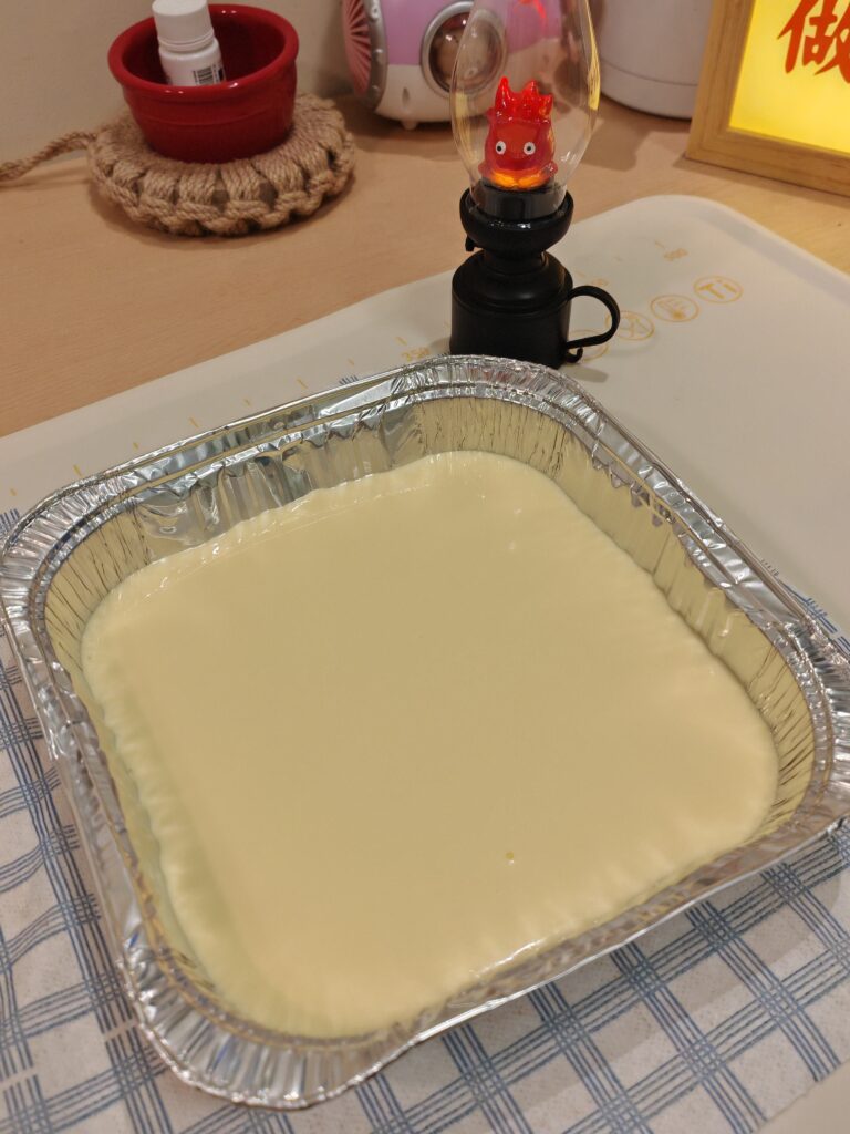 Raw Basque burnt cheesecake batter in a square foil pan ready for baking